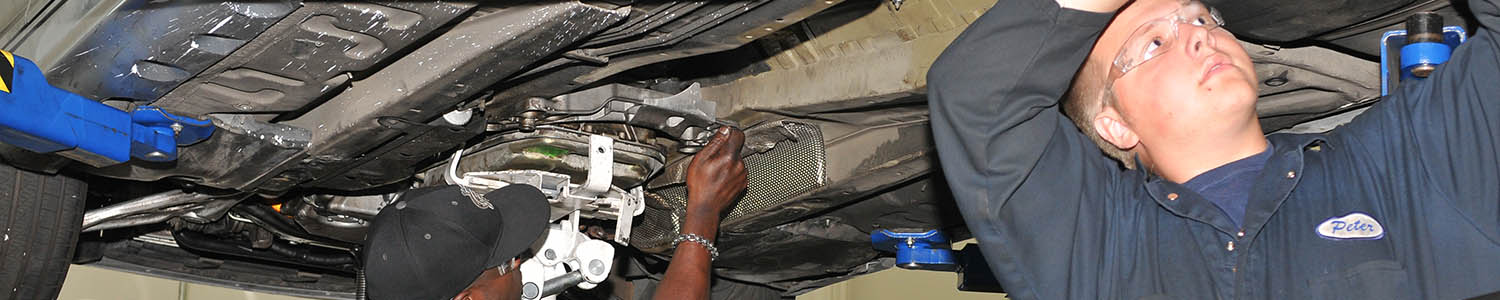 Students work on the undercarraige of a hoisted vehicle