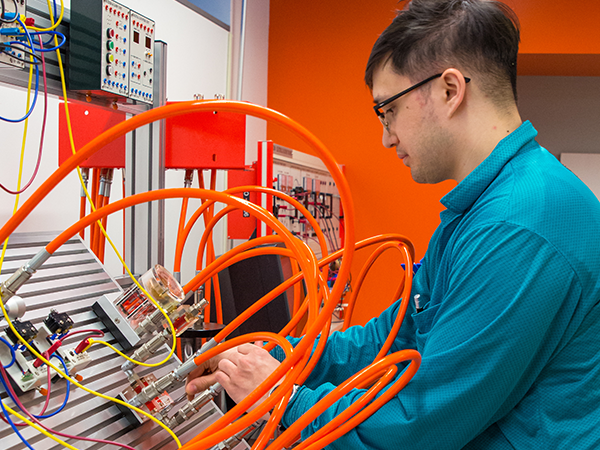Student working with cables at a technical interface board