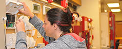 Female electrician student repairing equipment